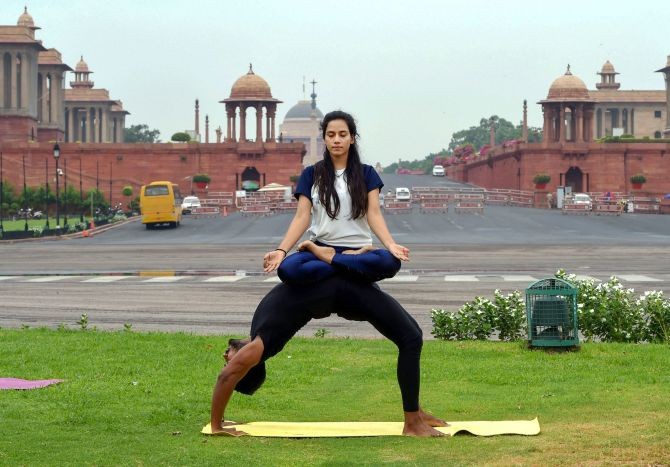  Youngsters perform 'yoga' at a lawn near Vijay Chowk on the 6th International Day of Yoga, in New Delhi, Sunday, June 21, 2020. (PTI Photo/Shahbaz Khan)